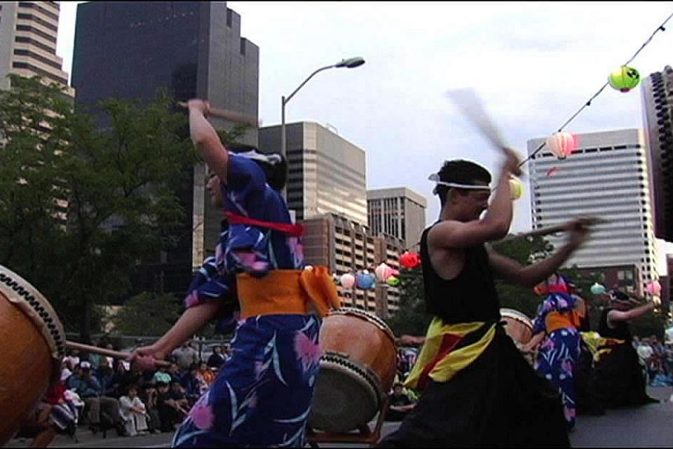 Members of Denver Taiko drum in the streets during a festival
